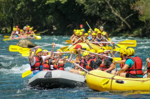 Tourists enjoying white water rafting, a popular Adventure Activities in Nepal experience surrounded by stunning natural scenery.