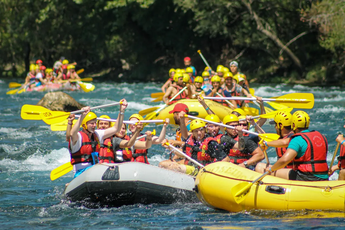 Tourists enjoying white water rafting, a popular Adventure Activities in Nepal experience surrounded by stunning natural scenery.