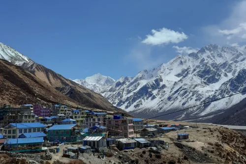 Langtang Valley Trek featuring Kyanjin Gompa village surrounded by snow-capped Himalayan peaks under a clear blue sky.