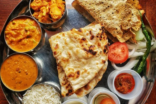 Dal Bhat served with rice, lentil soup, vegetable curry, roti, papad, yogurt, and chutney.