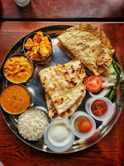 Dal Bhat served with rice, lentil soup, vegetable curry, roti, papad, yogurt, and chutney.