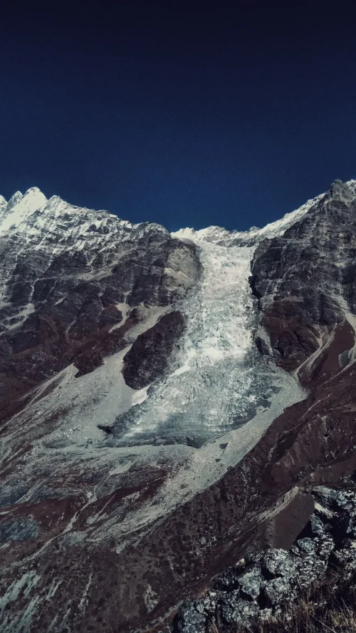 Climate change in Nepal affecting Himalayan glaciers, with a melting glacier surrounded by snow-covered mountain peaks.