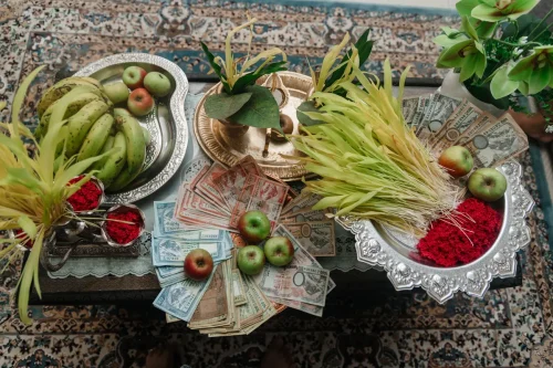 Dashain Festival offerings in Nepal featuring traditional flowers, fruits, tika, and Nepali banknotes arranged on silver trays.